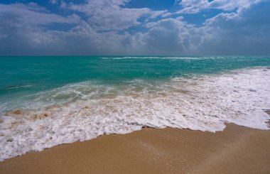 Okyanus dalgaları ve gökyüzünde kum. Fırtınalı deniz dalgaları. Yaz denizi dalgası. Köpüklü okyanus dalgaları. Yaz okyanus esintisi. Rüya gibi yaz sahili geçmişi. Okyanus sıçrama dalgaları