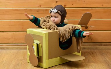 Çocuk hayal gücü kavramı. Hayali kanatlı bebek sineği. Çocukların hayal gücü macerası. Hayalperest çocuk uçmayı hayal eder. Karton kanatlar hayal gücünü harekete geçirir. Yaratıcı çocuk pilot hayal gücü