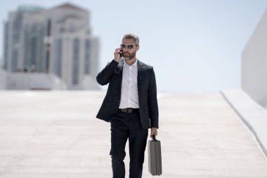 Zengin iş adamı dışarıda dolaşıyor. Çantası olan başarılı bir iş adamı. Lider harekete geçti. İş adamı güvenle yürüyor. Takım elbiseli bir iş adamı işe gidiyor. İş adamı profesyonel hareket halinde