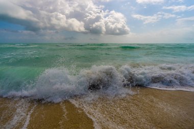 Kristal deniz kıyısı. Renkli deniz kıyısı suyu. Sıcak okyanus esintisi. Yaz sahili. Deniz arka planı. Mavi okyanus. Kumsal. Okyanus dalgaları. Yaz mevsimi. Tropik sahil şeridi. Köpüklü dalga sıçraması