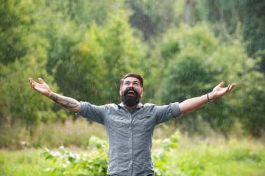 Dışarıda bir adam yağıyor. Olumlu düşün. Fırtınalı hava. Yağmurda meditasyon. Rahatlama kavramı