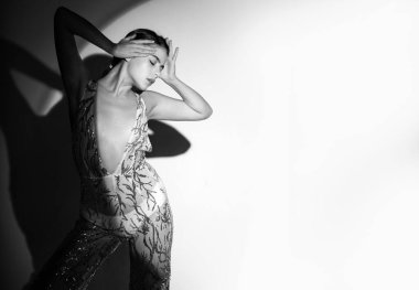 Stüdyoda zarif bir kadının yüksek moda portresi. Moda mankeni, güzel genç bir kadın. Vogue elbisesiyle poz veriyor. Stüdyo fotoğrafı.