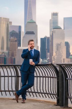 New York 'ta iş. Açık havada akıllı telefon kullanan bir iş adamı. Takım elbiseli bir iş adamı, Manhattan, New York 'taki uygulamalı mesajla cep telefonu kullanıyor. İş konuşmaları. Akıllı telefonlu bir iş adamı.