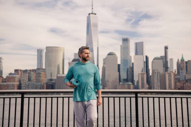 NYC 'de beden eğitimi son sınıf öğrencisi. Sağlıklı bir emeklilik hayatı. Aktif kıdemli adam dışarıda egzersiz yapıyor. Emeklilikten sonra aktif. Olgun emekli sporcu esneme egzersizleri yapıyor.