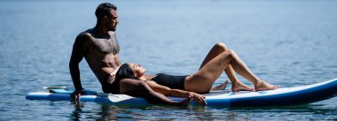 Yaz çifti dinleniyor. Sahil ve yaz tatili. Romantik çift dinleniyor. Seksi çiftler dinleniyor ve dinleniyor. Yaz tatilinde aşk. Şehvetli çift deniz suyunun yanında dinleniyor. Yaz tatili