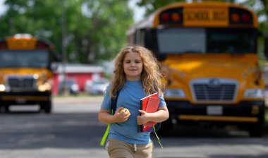 Okul otobüsü dışarıda çocuk öğrenciyi bekliyor. Sırt çantası ve okula gidecek kitapları olan bir çocuk. Devlet okuluna kadar yürüdüm. Amerikan okulunda eğitim, öğrenme ve bilgi kavramı
