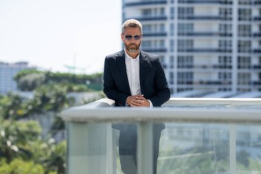 İş adamı kendinden emin duruyor. Başarılı bir iş adamı. Takım elbiseli bir yönetici. Yakışıklı iş adamı kendinden emin görünüyor. Şehir ortamında Orta Doğulu bir iş adamı. Ofis yakınlarında olgun bir işadamı