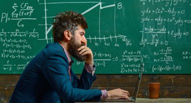 Öğretmen tahtada matematiği açıklıyor. Profesör karatahtayla sınıfta. Üniversite profesörü matematik formülü yazıyor. Sakallı öğretmen. Profesör sınıfta ders veriyor. Profesör matematiği açıklıyor