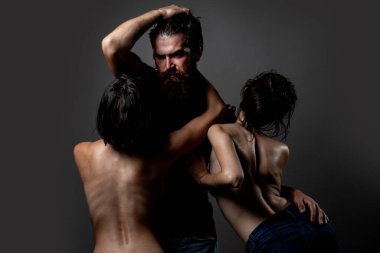 Üçlü konsept. Üç seksi model birlikte. Bir erkek ve iki seksi kadın. Çok eşlilik ya da iki eşlilik. Eş değiştiren ya da üçlü. Biseksüel kadın. Fahişelik ya da fantezi. Poliyamory ve çok eşlilik. Üçlünün Romantiği