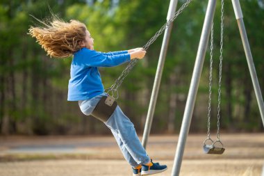 Mutlu çocuk eğleniyor. Çocuk bahçesinde mutlu bir çocuk. Havada sallanan kaygısız çocuk. Mutlu çocuklar dışarıda oynuyor. Sarışın çocuk heyecandan titriyor. Dışarıdaki oyuncu çocuk. Komik çocuk suratı