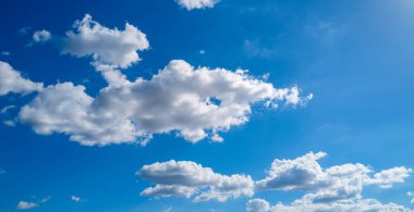 Mavi gökyüzünde beyaz bulutlar. Güzel güneşli gökyüzü. Mavi gökyüzünde bulutlar olan bir arka plan. Arkaplanda bulutlar