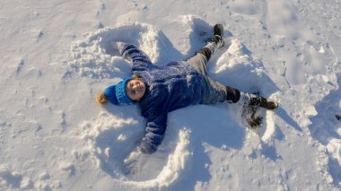 Kar meleği yapan bir çocuk. Karda yatan mutlu çocuk. Kardaki melek çocuk. Karlı melek kanatlı kış çocukları. Karlı bir günde gülümseyen bir çocuk. Kar Gölü Meleği 'ndeki kaygısız çocuk. Noel 'i Evlen
