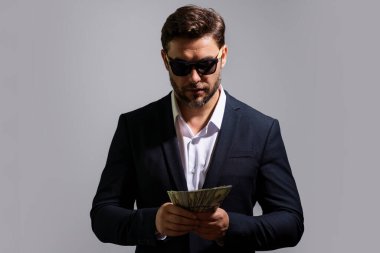 Dolar banknotları olan bir adam. Bir sürü 100 dolarlık banknot tutan bir iş adamı. Kolay para. Kara para. Ödeme günü ve ödeme konsepti. Kâr ve zenginlik. Para kazan. İş adamı başarılı anlaşma