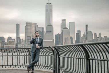 New York 'ta başarılı bir iş adamı. New York 'taki iş adamı. Takım elbiseli bir iş adamı. Şehir tarzında yakışıklı bir işadamının portresi. Olgun iş adamı sokakta yürüyor. Amerikan işleri.