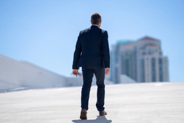 İş adamı tekrar dışarı çıkıyor. Takım elbiseli başarılı bir iş adamı. Kendine güveni tam bir iş adamı. İşadamı çekip gidiyor. Zarif takım elbiseli zengin adam. Kendine güvenen şehirli iş adamı.