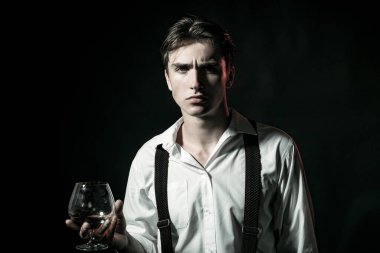 Barda viski içen bir adam. İçki içen yakışıklı bir adam. Ciddi yüzlü viski zamanı. Klasik viski bardağı tutan adam. Sadece viski içen bir adam.