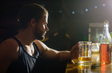 Alkol bağımlılığı. Karanlık bardaki üzgün adam. Alkol problemi. Restoranda içen yalnız bir adam. Alkol içmek. Bir bardak alkollü depresif bir adam. Sorumlulukla yüzleşen umutsuz alkolik