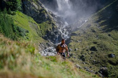 Yaz tatilindeki erkek turist. Yaz tatilinde çıplak gövdeli bir turist. Dışarıda güçlü bir İspanyol turist gezgini var. Şelalenin yanında yürüyen bir turist. Doğada seyahat. Tasasız ve özgür