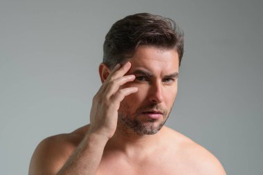 Yüz kremi süren güzel bir adamın güzel yüz portresi. Erkek için cilt kremi. Maske, deri değiştirme ve yaşlanmayı önleyici etki. Güzel erkek yüzü konsepti. Cilt bakımı ve yaşlanma. Yüz Kozmetiği