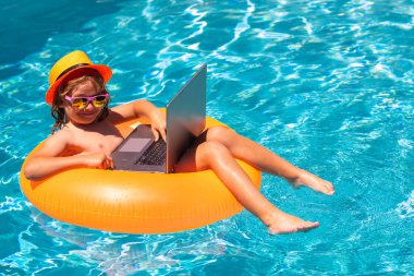 Yaz işi. Uzaktan kumandalı çocuk bilardoda çalışıyor. Küçük iş adamı bilardoda dizüstü bilgisayarda çalışıyor.