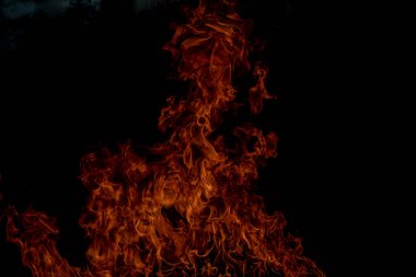 Siyah arka planda yangın alevleri. Ateş, izole edilmiş, soyut bir yapı. Yanma efektiyle yanan bir patlama. Duvar kağıdını ateşle, kopyalama alanı ile soyut sanat deseni