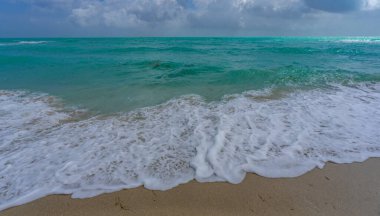 Deniz dalgaları arka planı. Tropik okyanus dalgaları. Mavi deniz manzaralı. Köpüklü sahil şeridi. Kumsal sahili arka planı. Deniz manzaralı duvar kağıdı. Turkuaz su hareketi. Deniz sahili dalgası. Mavi deniz dalgaları