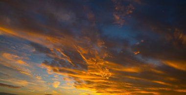 Gün doğumunda gökyüzü. Günbatımı arka planı. Gökyüzündeki bulutların arasından gün doğumu. Gündoğumu renkleriyle alacakaranlık gökyüzü. Yumuşak ışıkla huzurlu bir şafak. Bulutlu dramatik günbatımı. Açık gökyüzünde gün ışığı