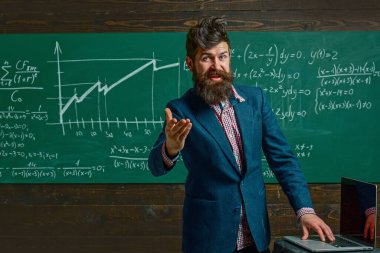 Öğretmen sınıfta matematiği açıklıyor. Profesör, matematik dersinde. Öğretmen matematik formülü yazıyor. Komik öğretmen. Profesör sınıfta ders veriyor. Öğretmen matematiği açıklıyor. Öğretmenler Günü