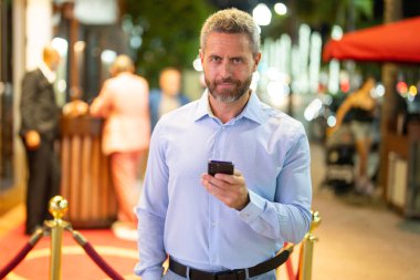 Gece kulübünün yakınında cüzdanı ve parası olan zengin bir iş adamı. Gece kulübü partisindeki zengin iş adamı. Gece lambalarında kendinden emin zengin bir adam. İş adamları için zengin bir gece hayatı. Zenginlik kavramı