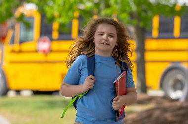 Okula dönelim. Genç öğrenciler için okul başlıyor. Okul otobüsünün yanında sırt çantalı bir çocuk. Çocuk okula gidiyor. Çocuk derse gidiyor. Okul çocuğu.