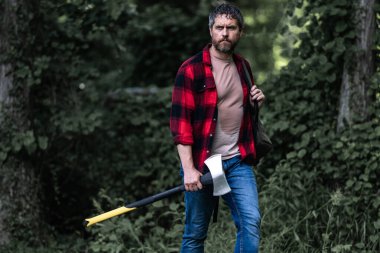 Oduncu ağacı baltayla kesiyor. Ormanda baltası olan yakışıklı bir adam. Yakışıklı ya da oduncu, sakallı, baltalı hippi. Büyük baltası olan sakallı bir oduncu.