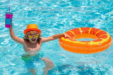 Çocuk yüzüyor ve havuzda oynuyor. Çocuk yüzme havuzunda oynuyor. Yazın çocukların portresi. Tropik bir tatil beldesinde tatil. Yaz çocukları kokteyli