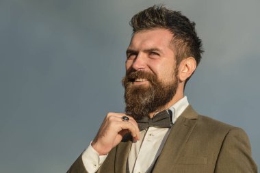 Sakallı adam. Sakallı ve bıyıklı şık bir hippi portresi. Yakından, sakallı, ciddi bir erkek yüzü. Eski moda berber dükkanı. Moda erkek sakalı ve bakımlı sakal. Berber dükkanı. Uzun sakal