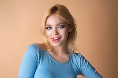 Genç bir kadın şakacı bir şekilde dilini uzatıyor. Dilini yalayan şehvetli bir kız. Dil ifadesine yakın çekim. Dilini gösteren genç bir esmer. Komik ve cilveli yüz hareketi