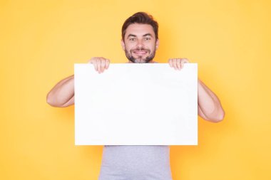 Boş pano konsepti. Mutlu adam tabelayı tutuyor, boş kart pankartı. Mesajını imzala. Gülümseyen adam stüdyo arka planında boş tabela gösteriyor. Boş tahta var. Alan reklamını kopyala