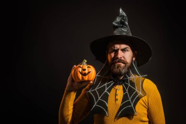 Cadılar Bayramı balkabaklı komik bir model. Cadılar Bayramı şapkalı balkabaklı insan portresi. Şeker mi şaka mı? Cadılar Bayramı şapkalı korkunç hippi. Cadı şapkalı adam balkabağını tutuyor. Baba, Cadılar Bayramı kutlu olsun.