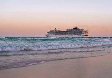 Okyanusta bir gemi turu. Denizde lüks bir yolcu gemisi. Yolcu gemisi olan Miami Plajı. Turkuaz su ve yolcu gemisi. Kıyıya yakın bir turist gemisi. Okyanus dalgaları ve tekne. Yaz tatili. Tekne gezisi