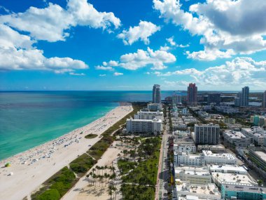 Miami 'de kumsalda güneşli yataklı, okyanus dalgalı bir plaj. Muhteşem manzaralı Miami Beach cenneti. Güney Sahili Miami cankurtaranı. Miami 'de huzurlu bir deniz kenarı inzivası. Kıyı gevşemesi