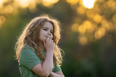 Çocuk başka tarafa bakıyor ve düşünüyor. Çocuk hayalperesti şüpheli bir bakışla düşünüyor. Derin düşünen bir çocuğun portresi. Hayalperest ergen çocuk düşüncelere daldı. Düşünceli yüzlü zeki çocuk. Hayal kuran çocuk