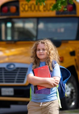 Okula dönelim. Genç öğrenciler için okul başlıyor. Okul otobüsünün yanında sırt çantalı bir çocuk. Çocuk okula gidiyor. Çocuk derse gidiyor. Okul çocuğu.