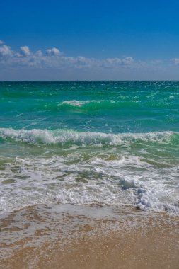 Deniz kıyısında dalga hareketi. Yaz okyanus esintisi. Deniz doğası arka planı. Huzurlu okyanus. Rüya gibi okyanus ufku. Kıyı okyanusu cennet duvar kâğıdı. Deniz köpüğü dalgaları. Gök mavisi su yüzeyi. Altın saat kumsalı