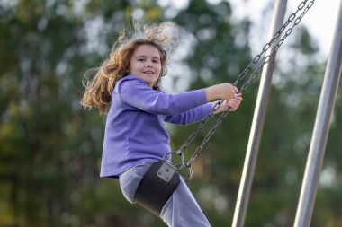 Çocuk salıncakta eğleniyor. Çocuk bahçesinde mutlu bir çocuk. Kaygısız çocuk dışarıda sallanıyor. Mutlu çocuklar dışarıda oynuyor. Sarışın çocuk heyecandan titriyor. Dışarıdaki oyuncu çocuk. Eğlenceli çocuk suratı