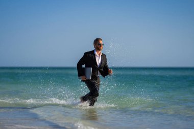 Bin yıllık heyecanlı İspanyol iş adamı. Takım elbiseli, denizde. Yaz tatili, deniz sahilinde iş. 40 'lı yılların iş adamı yaz seyahatinde. Yaz tatilleri için ofis çalışanları hayal edin.