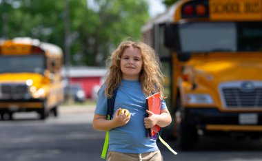 Okul otobüsü dışarıda çocuk öğrenciyi bekliyor. Sırt çantası ve okula gidecek kitapları olan bir çocuk. Devlet okuluna kadar yürüdüm. Amerikan okulunda eğitim, öğrenme ve bilgi kavramı