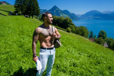 Kırsal kesimde tarla işçisi. Çiftlikte çalışan taşralı adam. Kırsaldaki güçlü kaslı çiftçi. Kırsal kesim işçisi tarlada ot topluyor. Kırsal kesimde amelelik yapan kaslı bir adam.