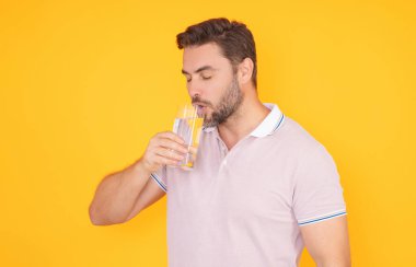 Stüdyonun arka planında izole edilmiş taze su içen adam. Adam bir bardak su tutuyor. Maden suyu içeceği, günlük su, susuzluk. Su içen insan portresi