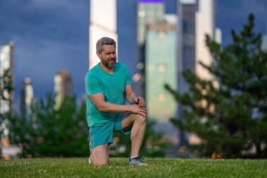 Dizler üstüne dizler. Adam bacak ağrısıyla boğuşuyor. Dizini tutan yaralı bir adam. Koştuktan sonra bacakları ağrıyor. Dizinden yaralanan bir adam. Antrenman bacak ağrısı. Koşu diz travmasına yol açıyor. Bacak ağrısı.