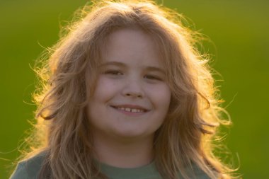 Yazın çekilen çocuk portresi. Çocuk suratı. Mutlu bir çocuğun yaz portresi. Çocuk yüzü parkta. Dışarıdaki neşeli çocuğun sevimli yüzü. Eğlenceli bir çocuk yüzü. Çocuk yazın tadını çıkarıyor. Yaz titreşimleri