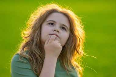 Çocuk başka tarafa bakıyor ve düşünüyor. Çocuk hayalperesti şüpheli bir bakışla düşünüyor. Derin düşünen bir çocuğun portresi. Hayalperest ergen çocuk düşüncelere daldı. Düşünceli yüzlü zeki çocuk. Hayal kuran çocuk
