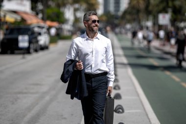 İş adamı işe yürüyerek gider. Hispanik iş adamı sokakta güven içinde yürüyor. Ofis çalışanı ofise gidiyor. Olgun bir iş adamı şehirde yürüyor. Dışarıda dolaşan gömlekli bir iş adamı.